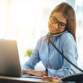 Telefonierende Frau mit Laptop