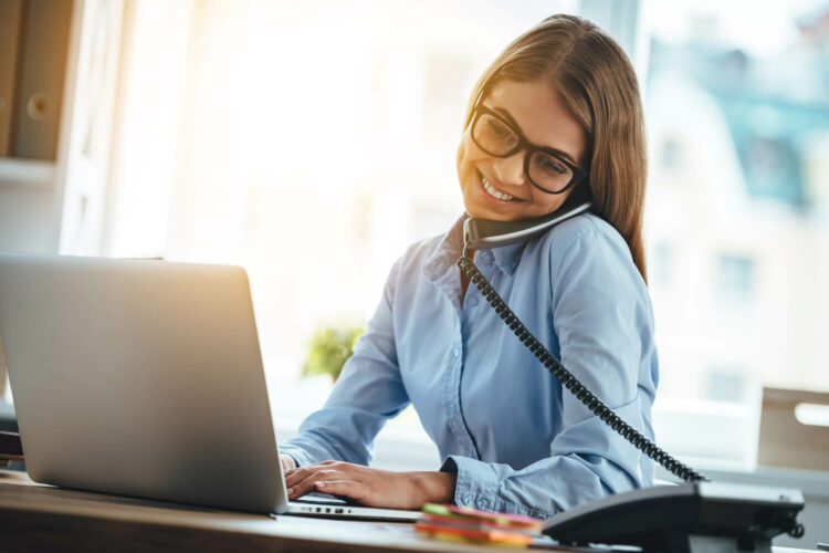 Telefonierende Frau mit Laptop