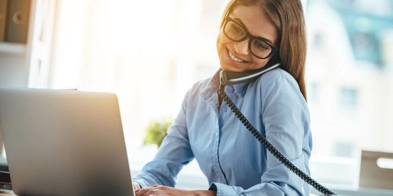 Telefonierende Frau mit Laptop